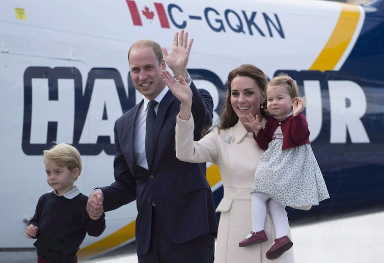 The Duke and Duchess wave as the Duchess holds her daughter and the Duke holds the hand of his son.