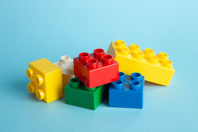 A heap of yellow, red, green and blue Lego in a heap.