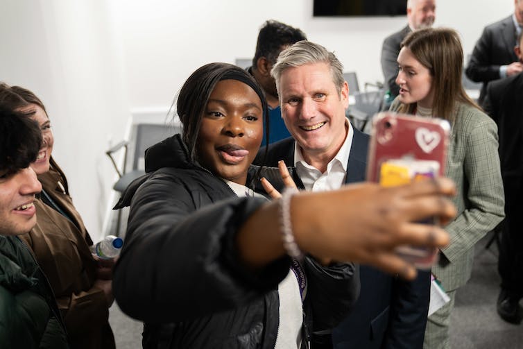 Keir Starmer poses for a selfie with a young woman