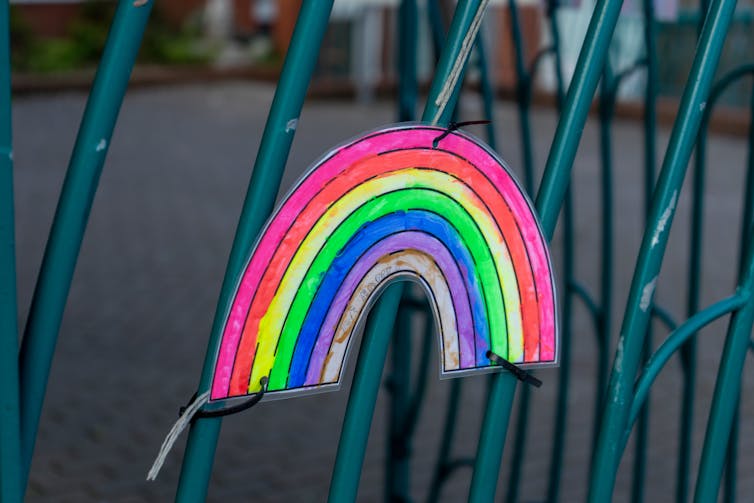 A rainbow attached to a school gate during COVID-19.